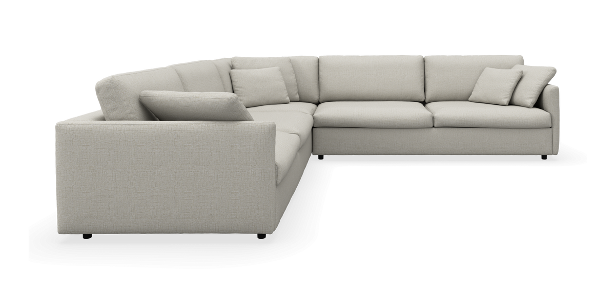L-formet beige hjørnesofa med løse puder, fritlagt produktbillede.