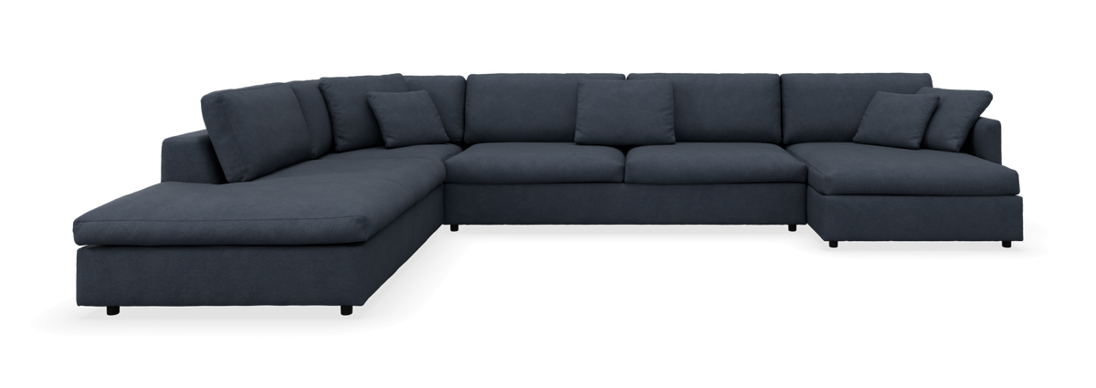Mørkeblå U‑formet modulsofa med chaiselong i begge sider og flere puder, frontvisning, frilagt.