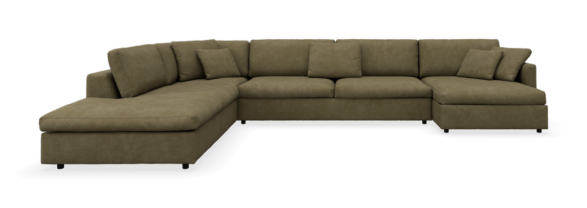 Grøn L-formet modulsofa med chaiselong og løse puder, frilagt på sort baggrund.