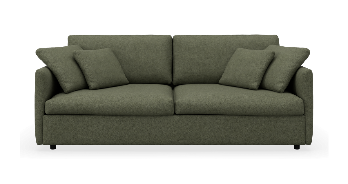 Frontvisning af grøn sofa med puder, frilagt på hvid baggrund.