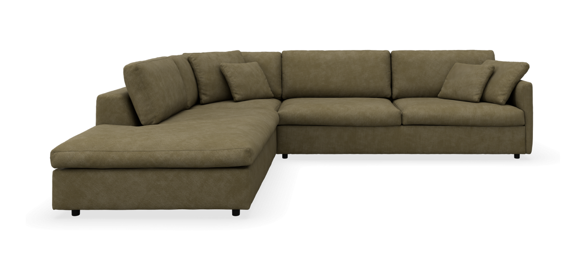 Olivengrøn L-formet hjørnesofa med chaiselong og løse puder, frilagt i studiemiljø.