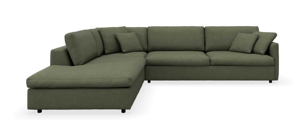 Grøn hjørnesofa med venstrevendt chaiselong og løse puder.