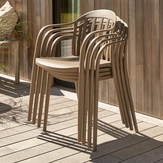 Stablede beige udestole på en træterrasse i sollys.