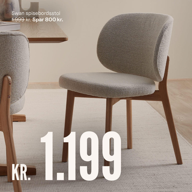 Swan spisebordsstol i lysegråt stof med egetræsbene i en rolig spisestue. Pris 1.199 kr, spar 800 kr (før 1.999 kr).