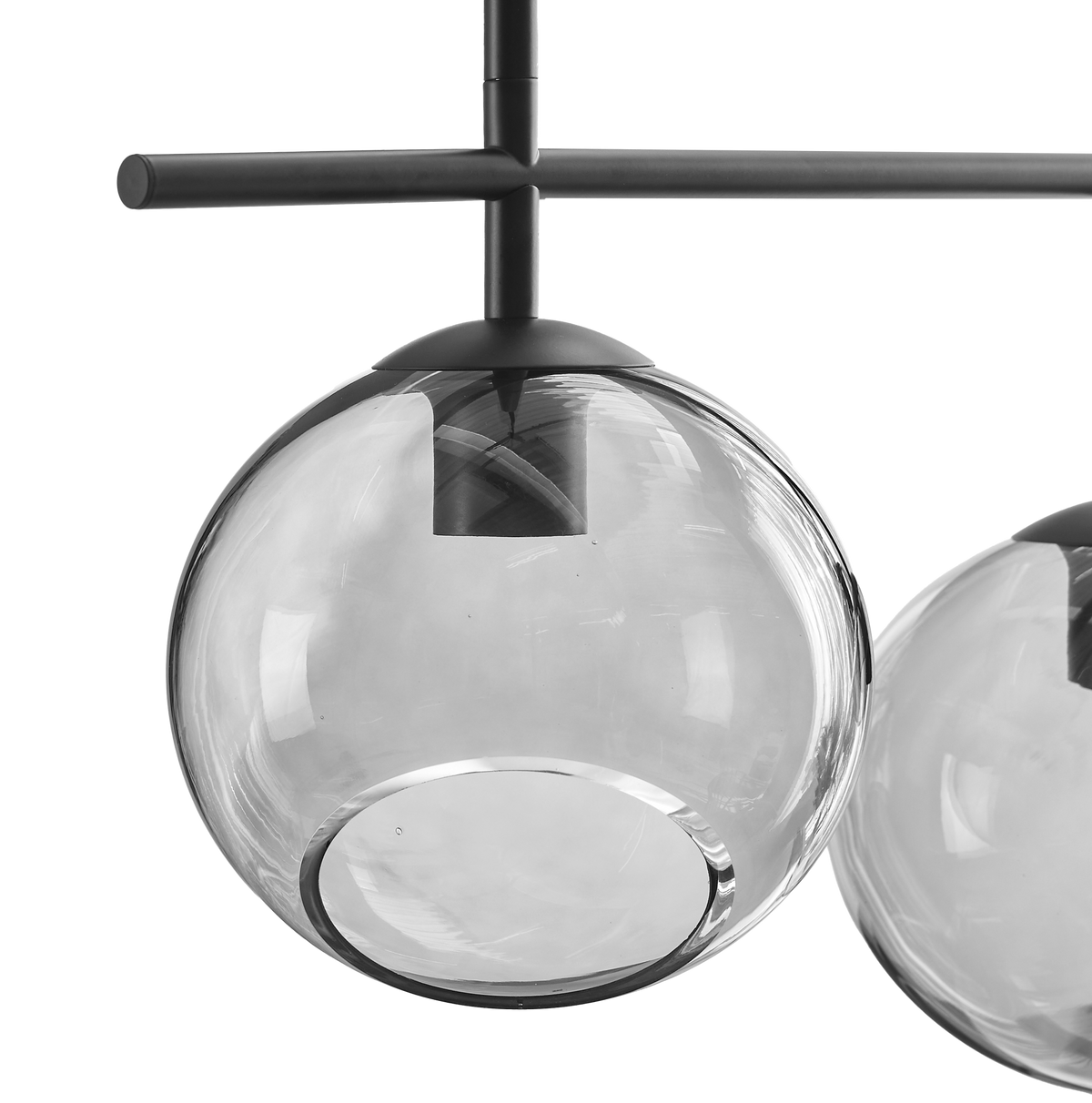 Kugleformet pendellampe i klart glas med sort metalophæng, nærbillede på hvid baggrund.