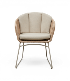 Lys beige loungestol med flettet rattanramme, polstret sæde og tredelt ryg på slanke metalben.