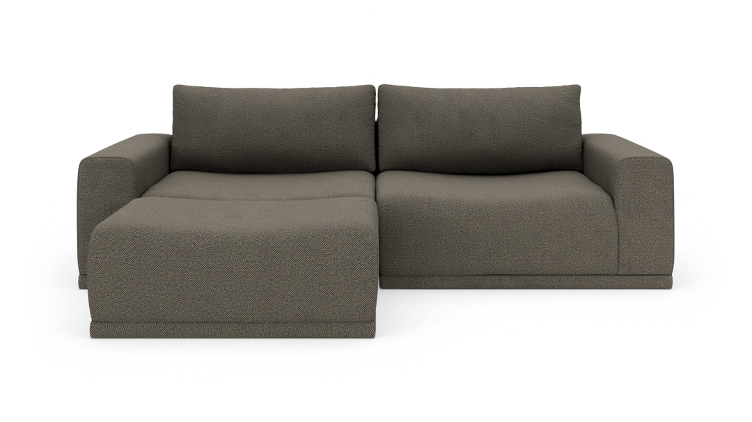 Modulsofa med venstrevendt chaiselong i mørkegråt stof, fotograferet lige for i studie.