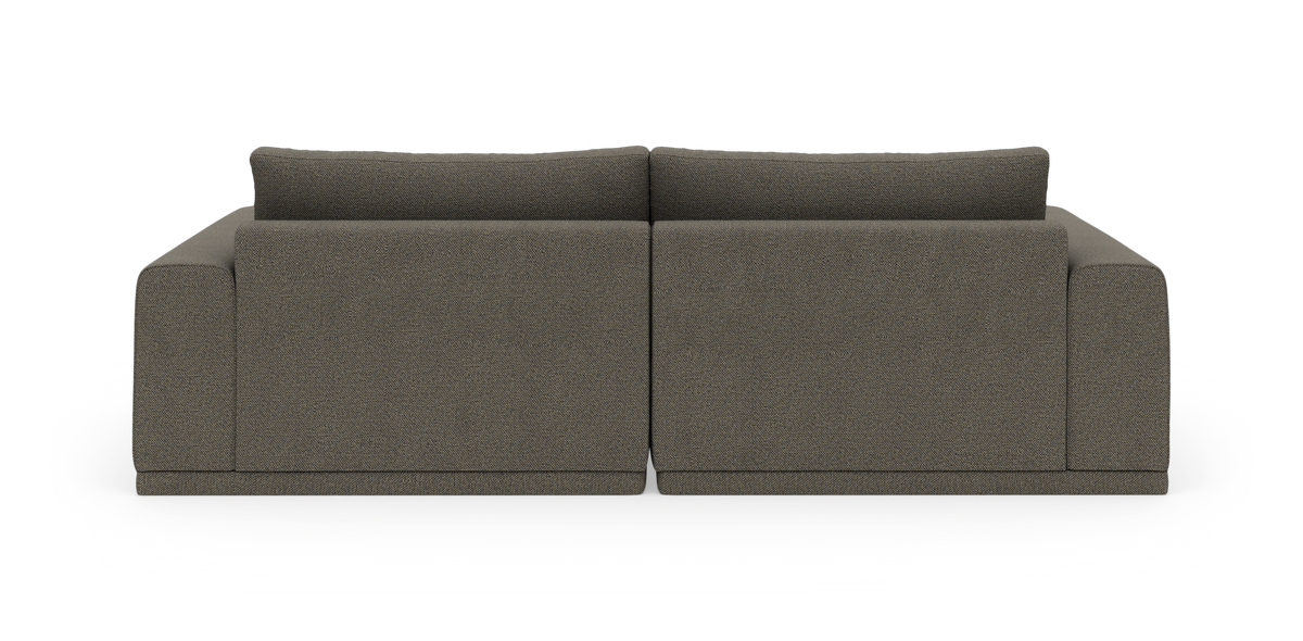 Mørkegrå modulsofa i stof, set bagfra, centreret mod hvid studiobaggrund.