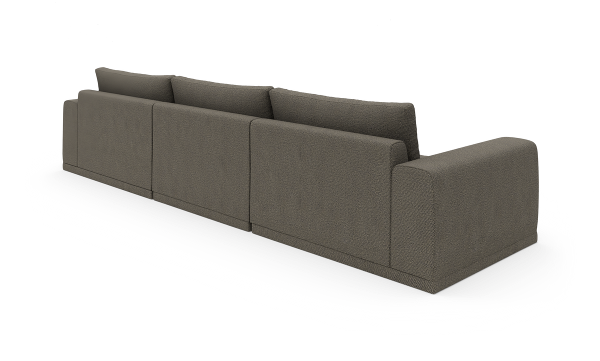 Modulær, mørkegrå stofsofa set bagfra i skrå vinkel, fritstående på hvid studiebaggrund.