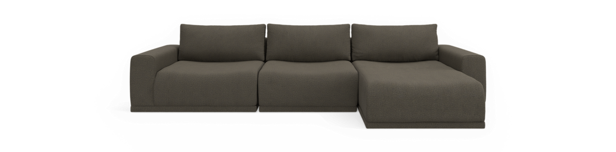 Front af en moderne tresæders modulsofa med højre chaiselong i mørkegråt stof, frilagt mod sort baggrund.