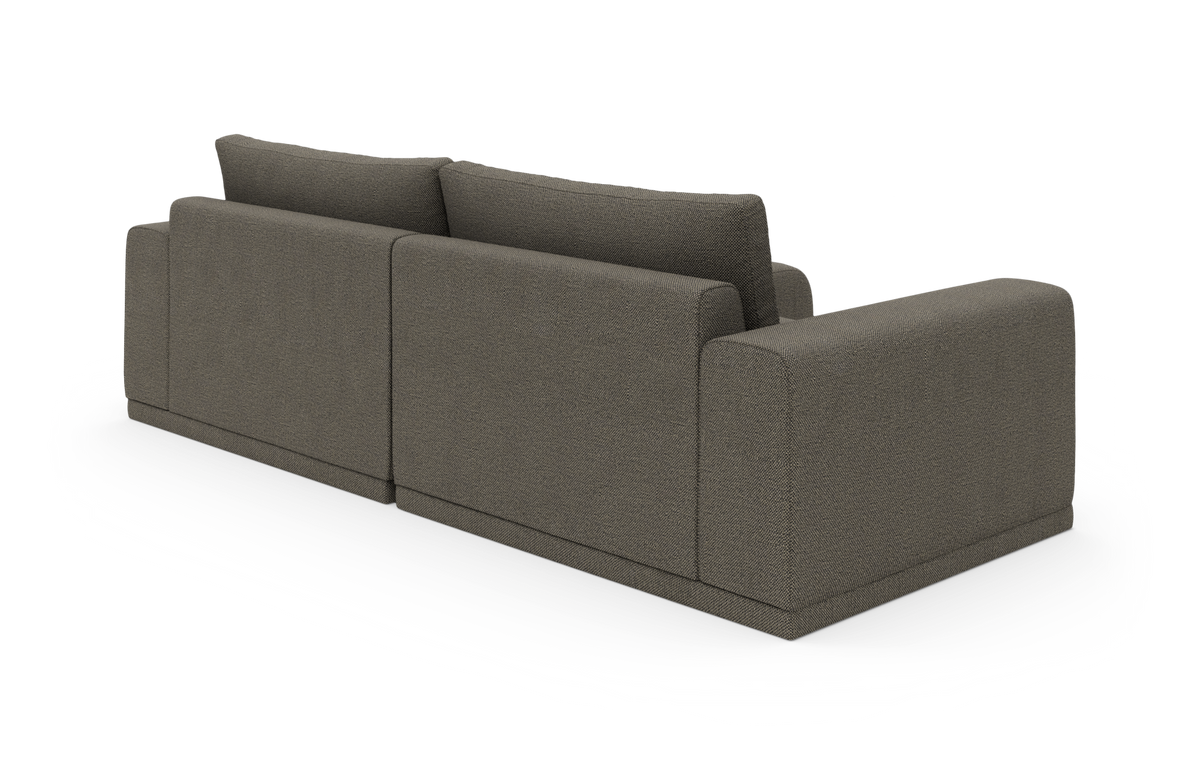 Modulær grå hjørnesofa med afrundede armlæn set skråt bagfra på hvid baggrund.
