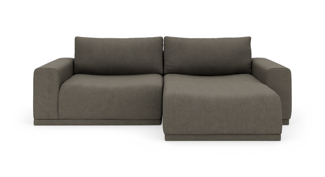 Mørkegrå modulsofa med chaiselong til højre, frontvisning, frilagt mod hvid baggrund.