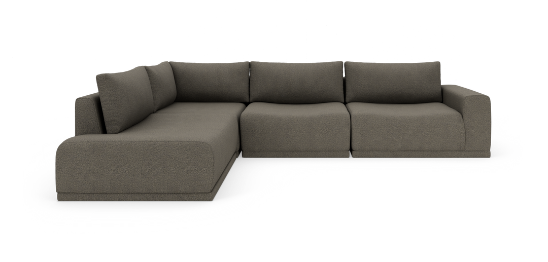 Modulsofa i L‑form i mørkegråt tekstil med brede armlæn og løse ryghynder.