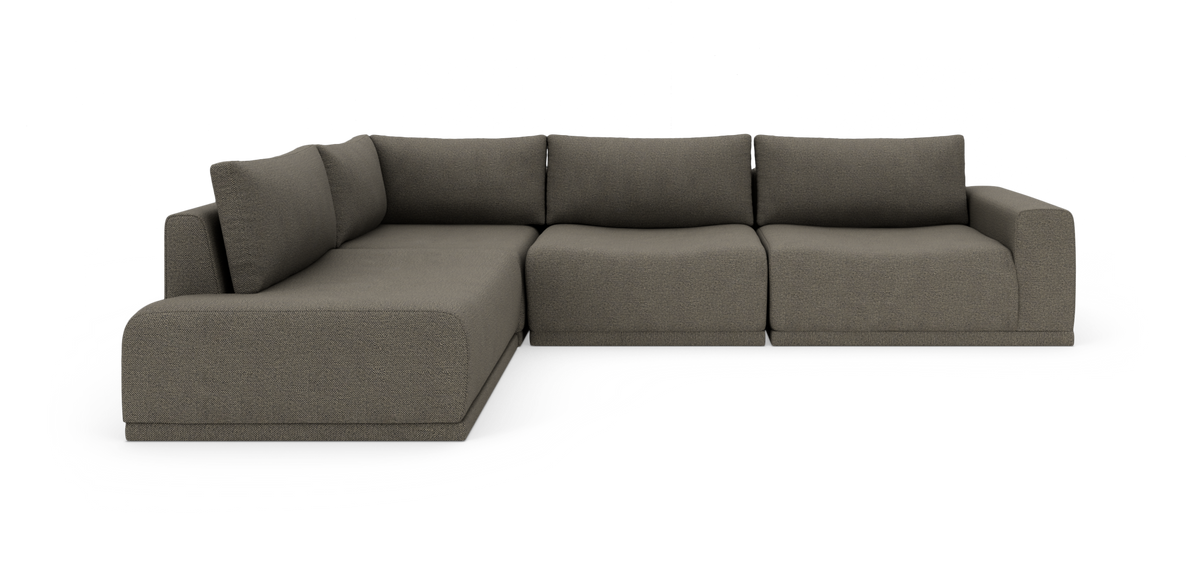 Modulsofa i L‑form i mørkegråt tekstil med brede armlæn og løse ryghynder.