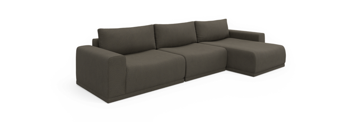 Mørkegrå modulsofa med chaiselong til højre, tre ryghynder og brede armlæn, fritlagt på sort baggrund.