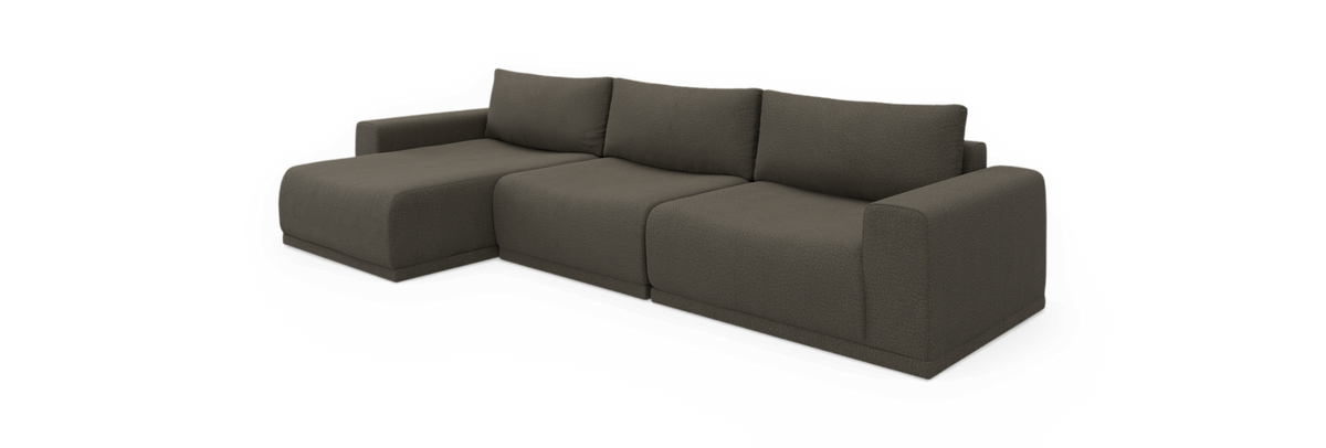 Modulær L‑sofa med venstrevendt chaiselong i mørk taupe stof, fritstående mod sort baggrund.