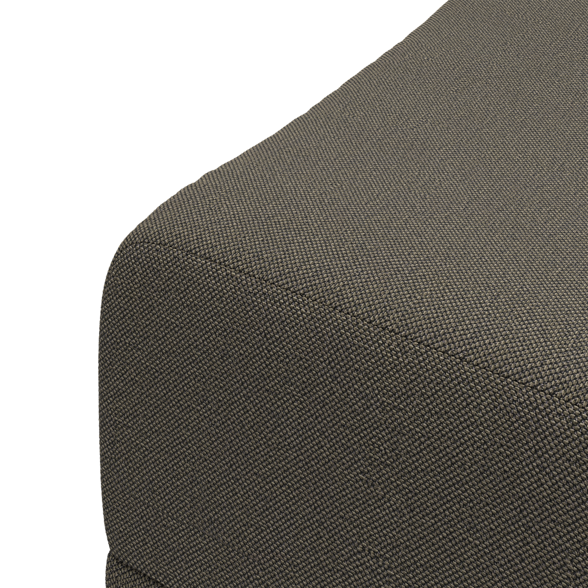 Nærbillede af hjørnet på en mørkegrå tekstilbetrukket puf/sofa med grovvævet struktur, frilagt mod hvid baggrund.
