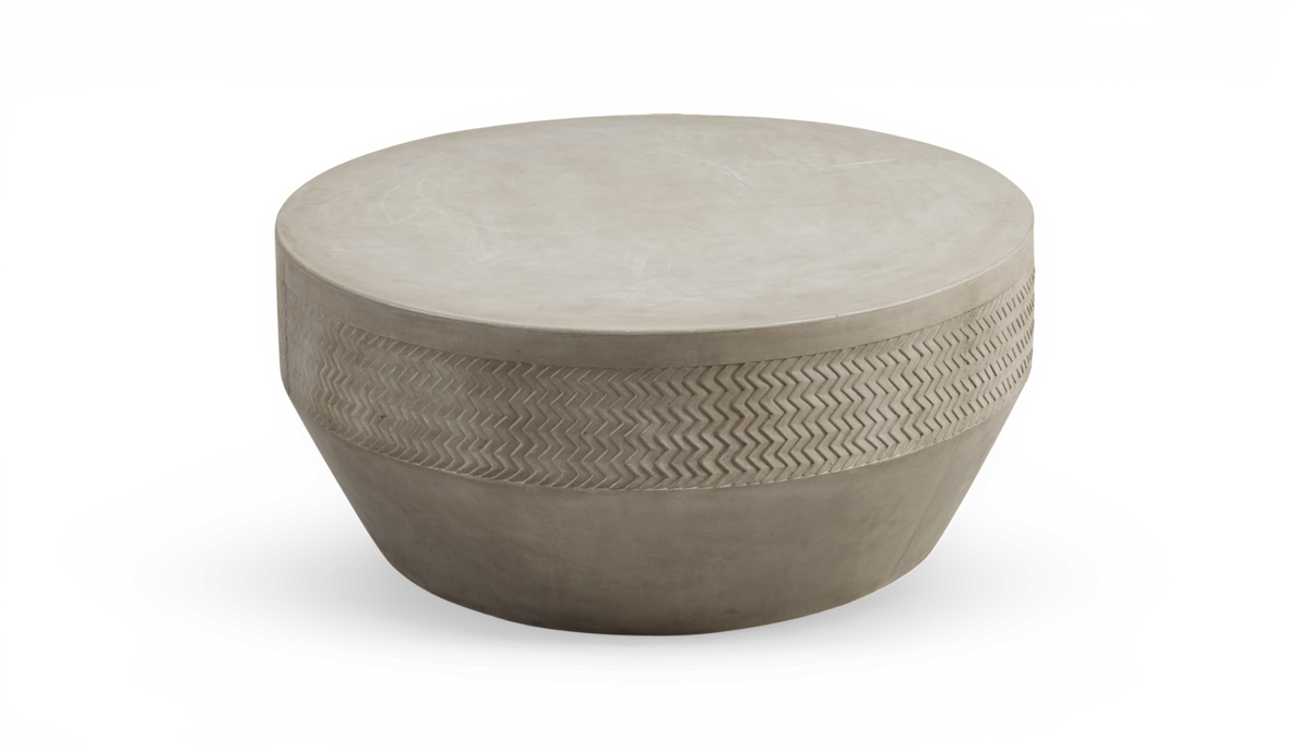 Rundt sofabord i beton med diskret zigzag‑relief rundt kanten.