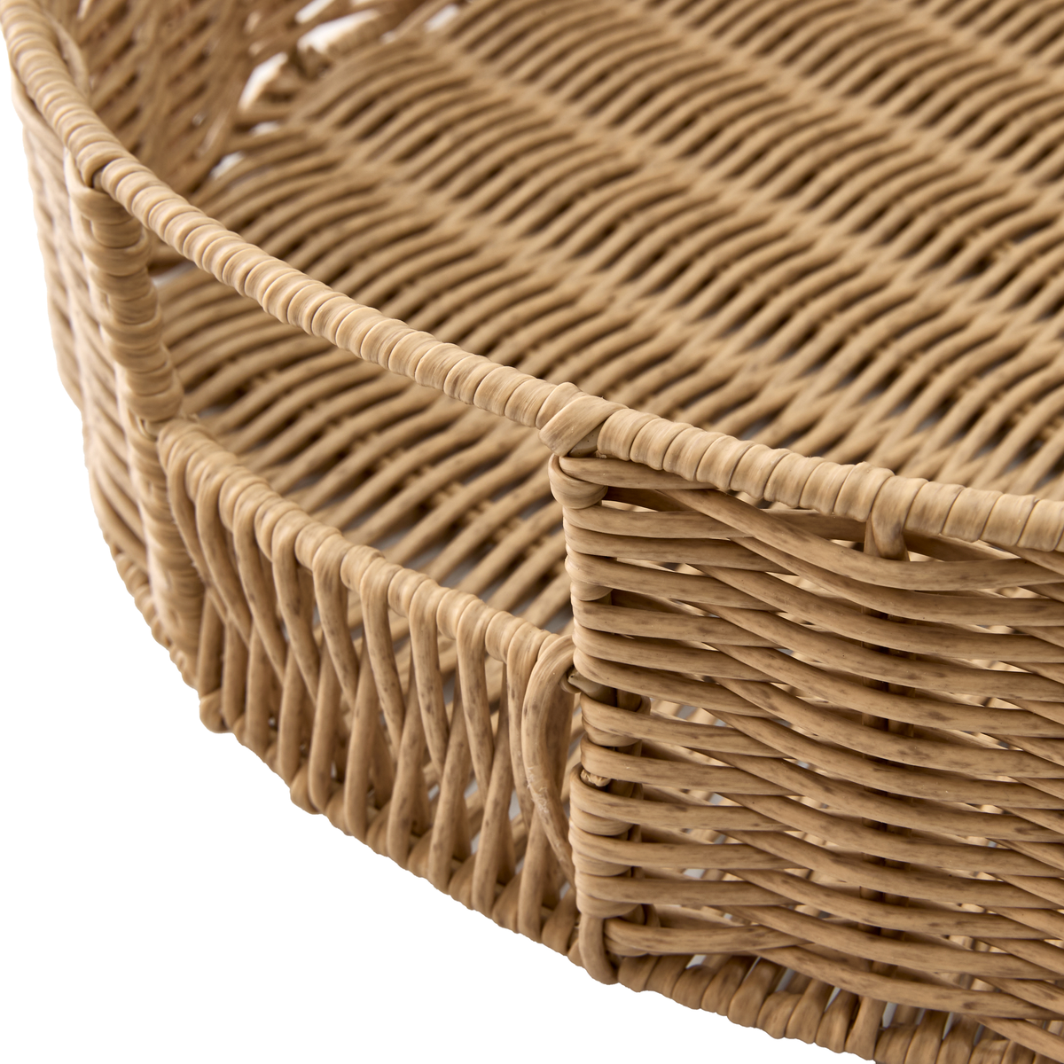 Nærbillede af rund flettet bakke i naturfarvet rattan.