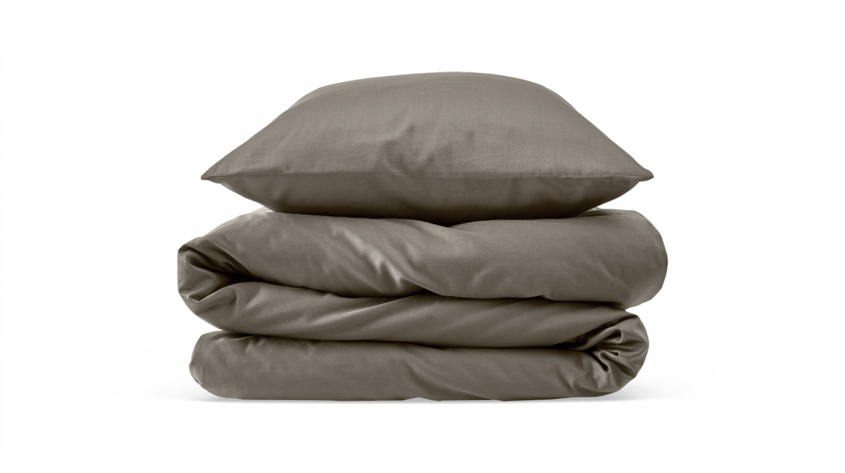 Sammenfoldet dyne med pude i taupe, produktfoto på hvid baggrund.