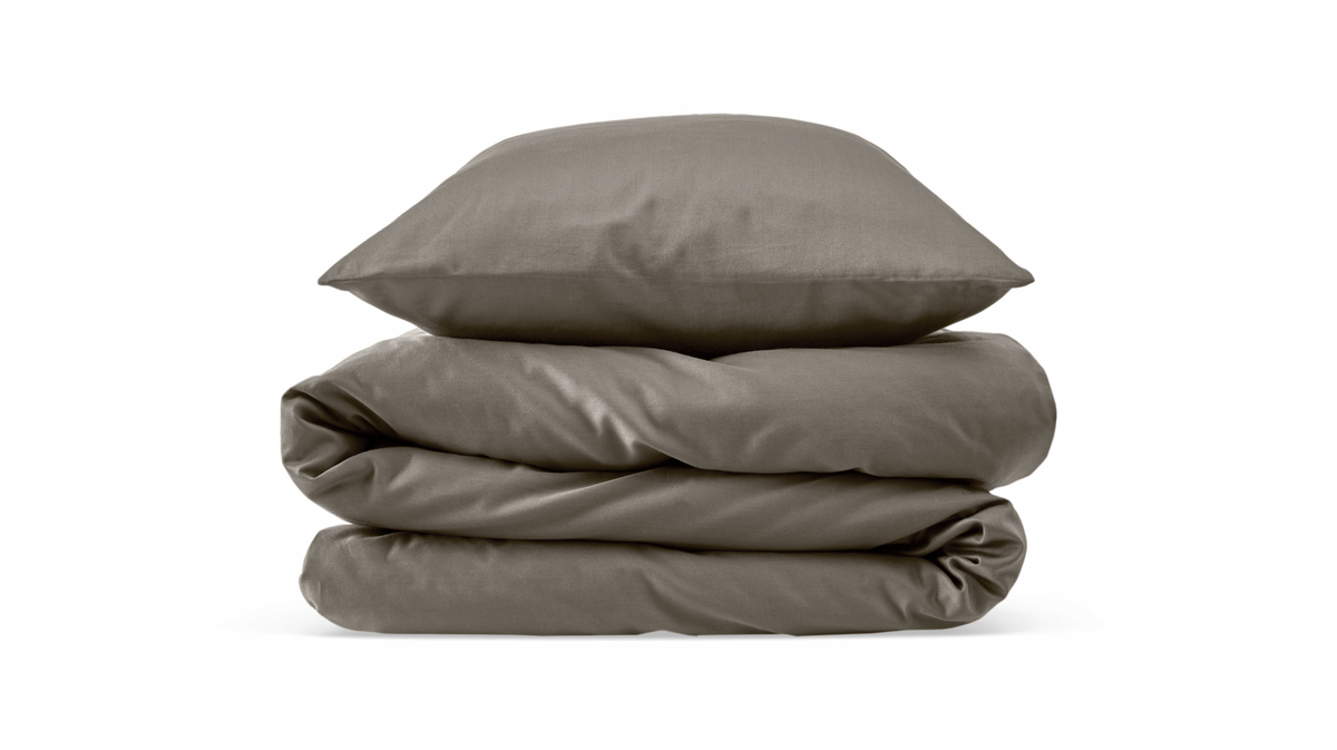 Sammenfoldet dyne i taupe med matchende pude på hvid baggrund.
