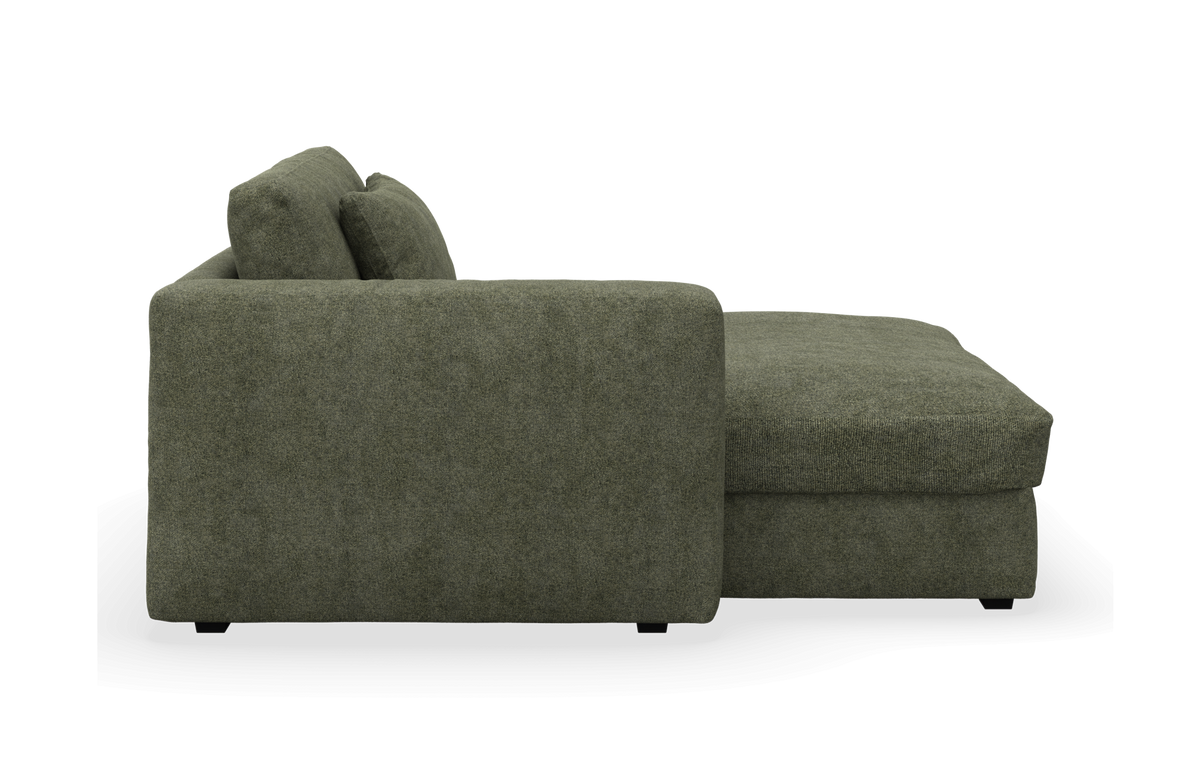 Grøn chaiselong-sofa set fra siden på hvid baggrund.