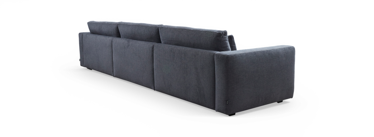 Mørkegrå modulsofa set bagfra, fritlagt på sort baggrund.