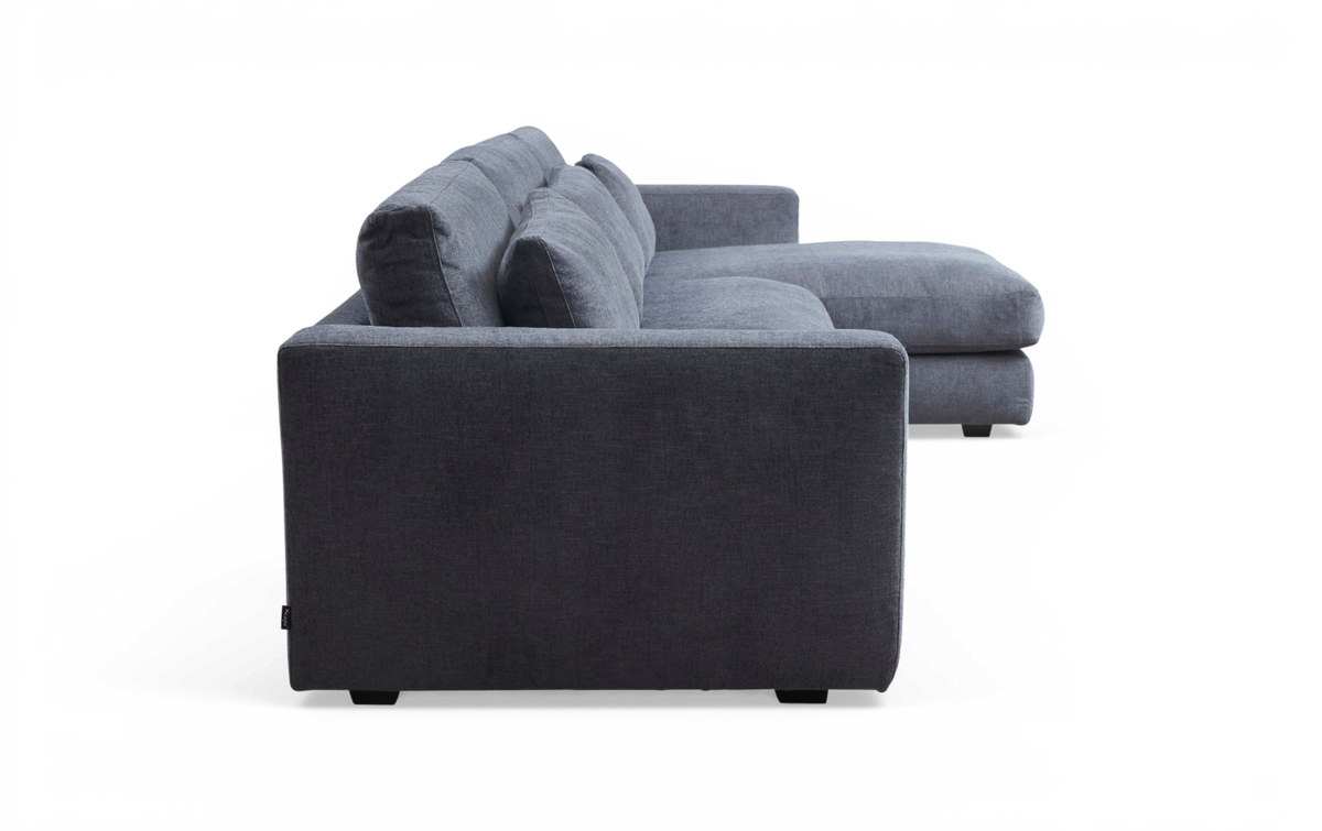 Grå modulsofa med chaiselong set fra siden på hvid/transparent baggrund.