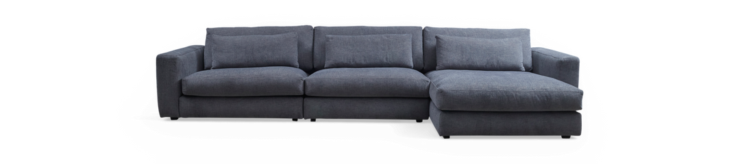 Mørkegrå modulsofa med chaiselong til højre på sort baggrund.