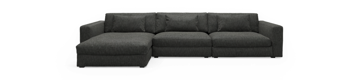 Mørkegrå modulsofa med venstrevendt chaiselong, frilagt på sort baggrund.