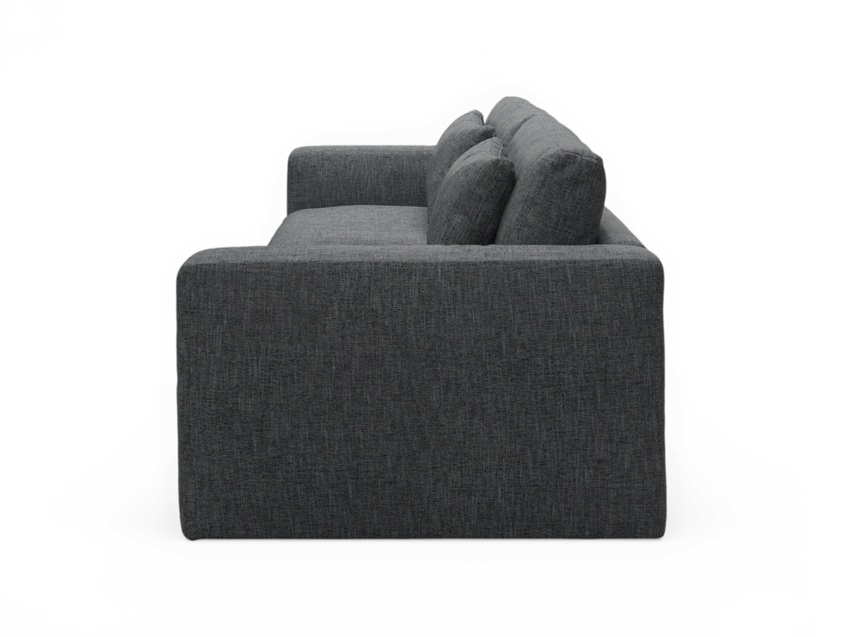 Mørkegrå stofsofa set fra siden med store ryghynder.