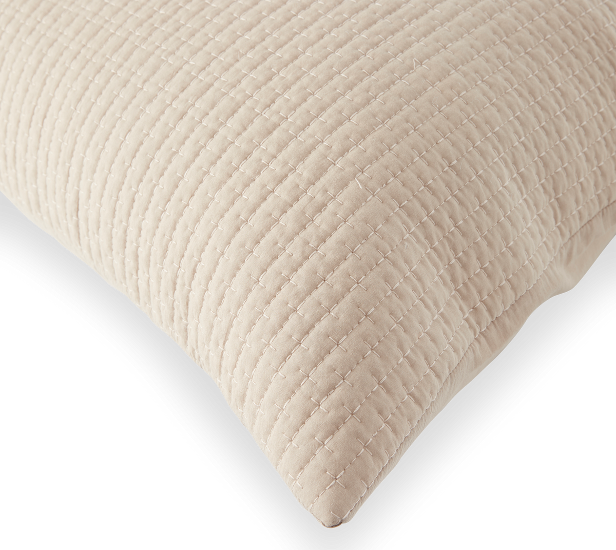 Beige quiltet pude med krydsstingsmønster på sort baggrund.