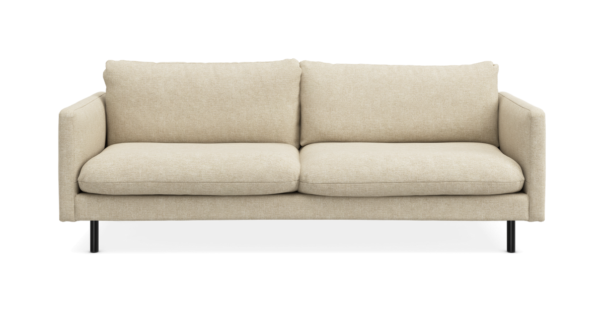 Beige 2-pers. sofa med bløde puder og slanke sorte ben, fritlagt forfra.