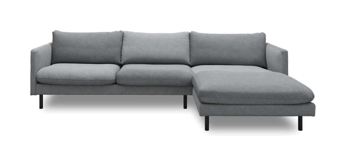 Grå hjørnesofa med chaiselong til højre i moderne, minimalistisk design.