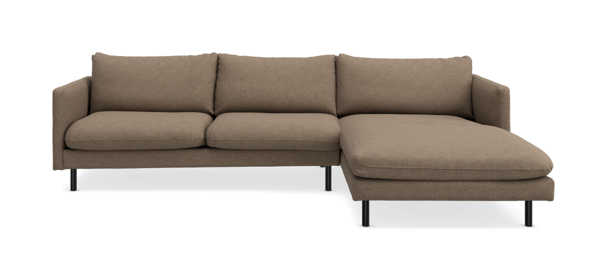 Højrevendt hjørnesofa i beige stof med chaiselong og sorte ben.