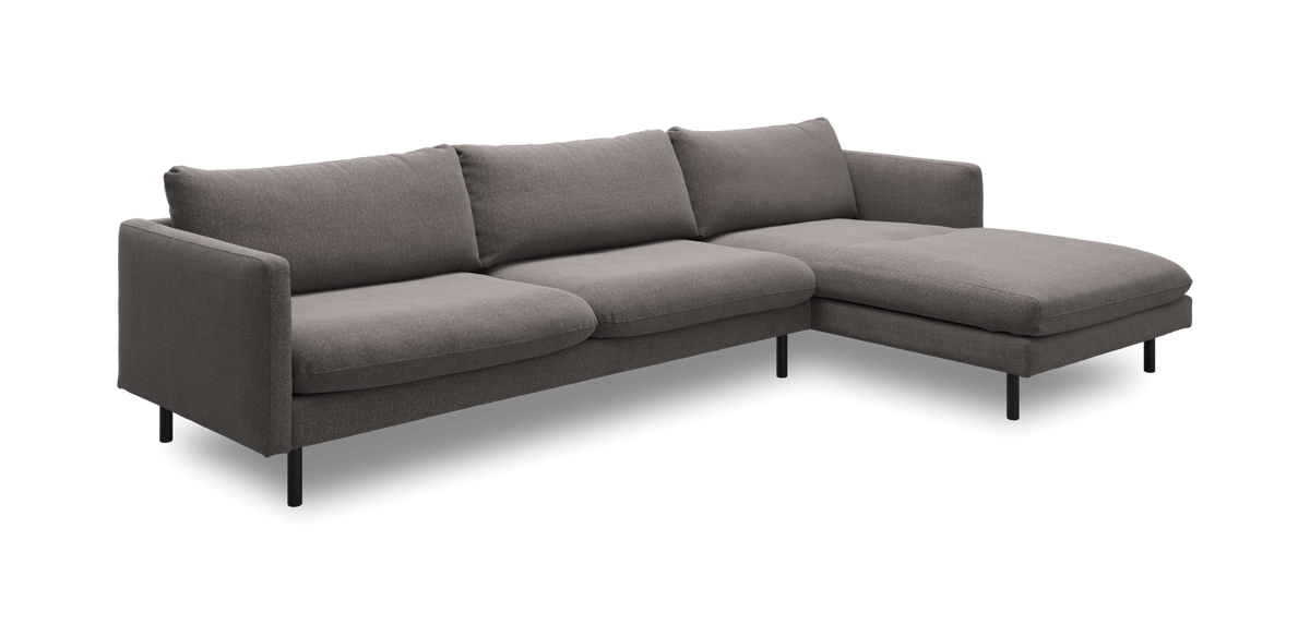 Grå hjørnesofa med chaiselong til højre i moderne, minimalistisk design.