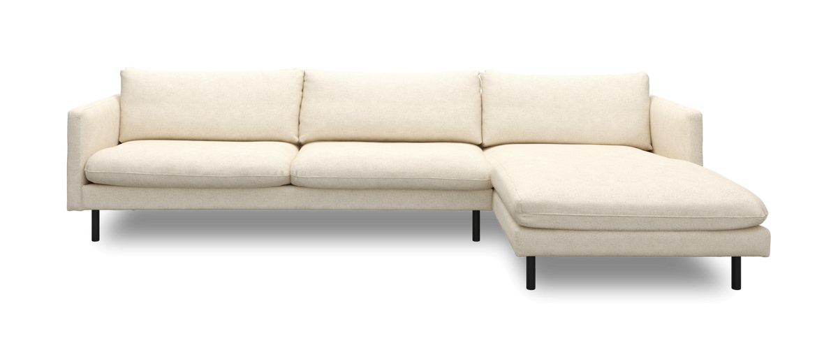 Beige hjørnesofa med chaiselong til højre og slanke sorte ben, set forfra.