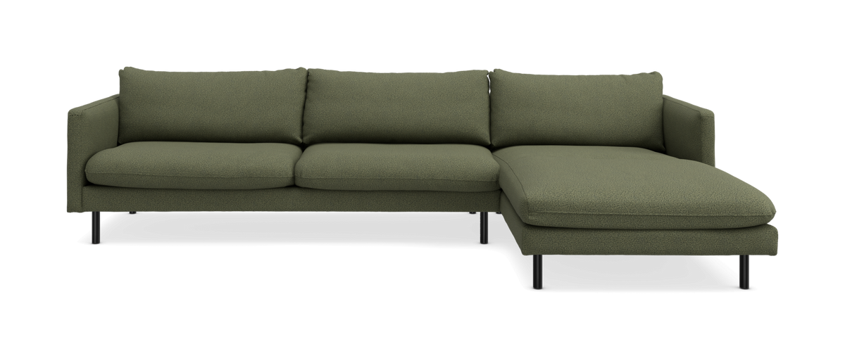 Grøn hjørnesofa med højre chaiselong, tredelt sæde og slanke sorte ben.