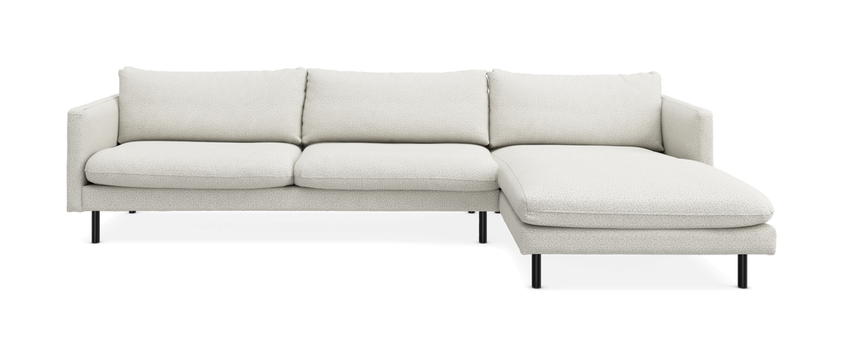 Lys beige hjørnesofa med chaiselong til højre på sorte ben.