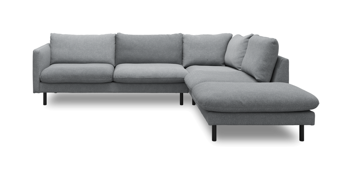 Grå L‑sofa med chaiselong på højre side og sorte ben, frilagt på hvid baggrund.