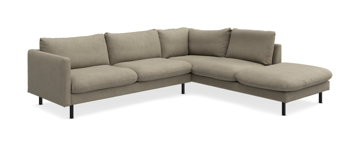 Beige L‑formet modulsofa med chaiselong til højre og slanke sorte ben.
