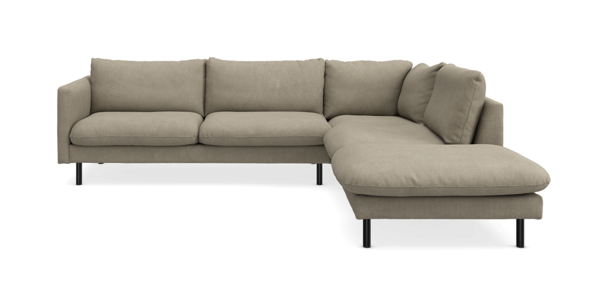 Beige hjørnesofa med chaiselong til højre, stofbetrukket med sorte ben, på hvid baggrund.