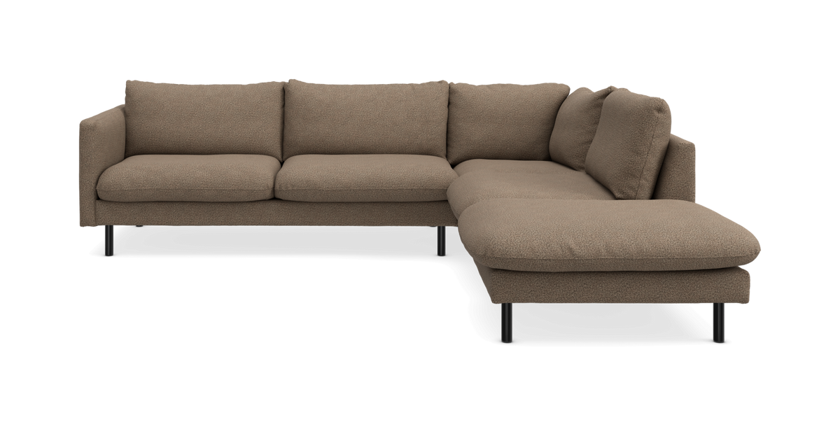 Brun L-formet hjørnesofa med chaiselong til højre i tekstureret stof og slanke sorte ben, frilagt.