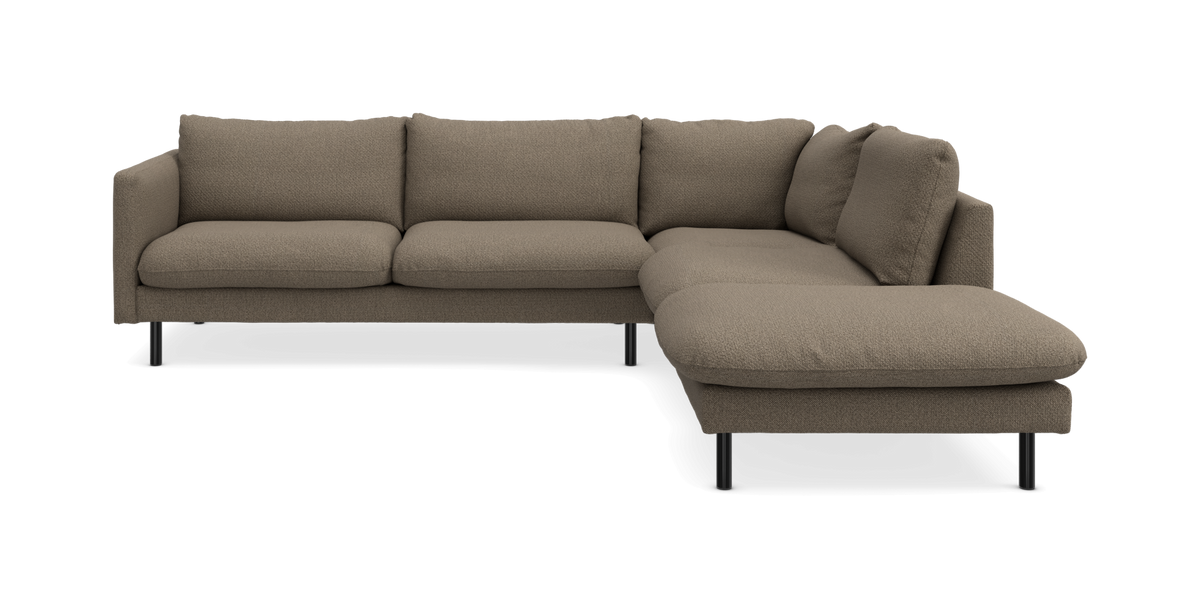 Hjørnesofa i beige stof med chaiselong til højre på slanke sorte ben.