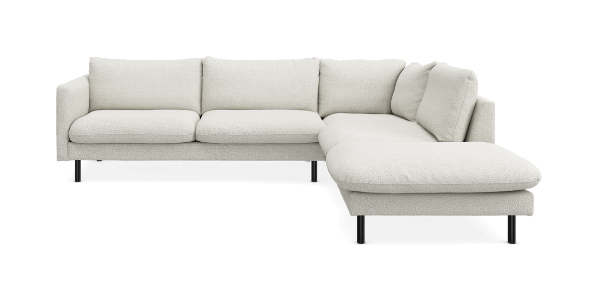 Hvid L-sofa med chaiselong til højre, moderne design på sorte ben.