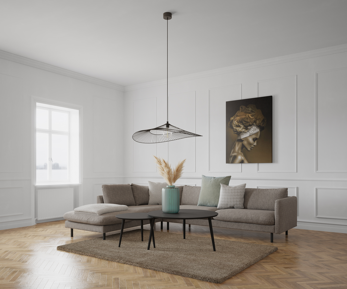 Lys skandinavisk stue med grå hjørnesofa, sorte sofaborde, mintgrøn vase med tørrede strå, beige tæppe og sildebensparket. Hvid vægpanel, stort vindue og en moderne net-pendel; på væggen hænger et kunsttryk med ansigtet sløret.