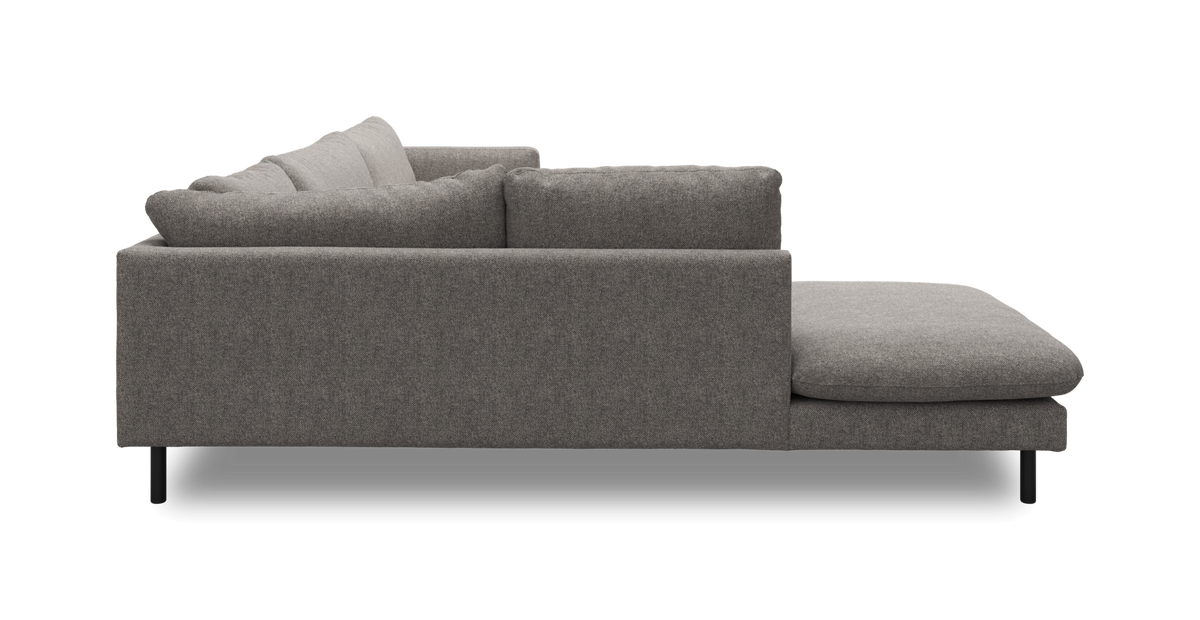 Grå stofsofa med chaiselong til højre, set fra siden.