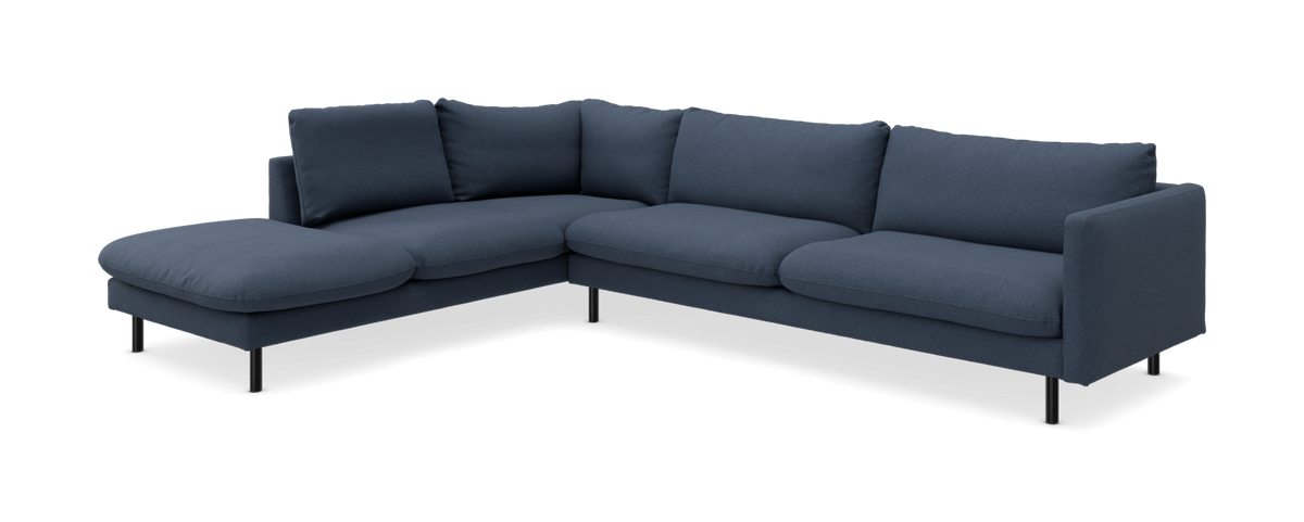 Blå L‑formet hjørnesofa med chaiselong til venstre, fritstående mod hvid baggrund.