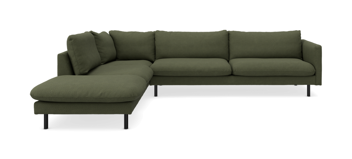 Grøn L‑formet hjørnesofa med chaiselong i boucléstof og sorte ben, frilagt studiobillede let skråt forfra.