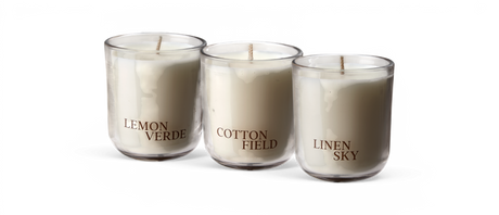 Tre hvide duftlys i glas med etiketterne LEMON VERDE, COTTON FIELD og LINEN SKY.